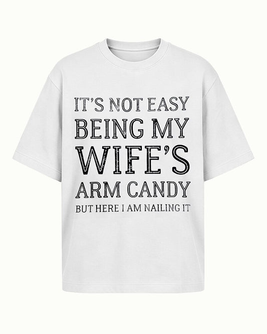 It's Not Easy Being My Wife's Arm Candy, but Here I Am Nailing It quote on Apricot cotton T-shirt