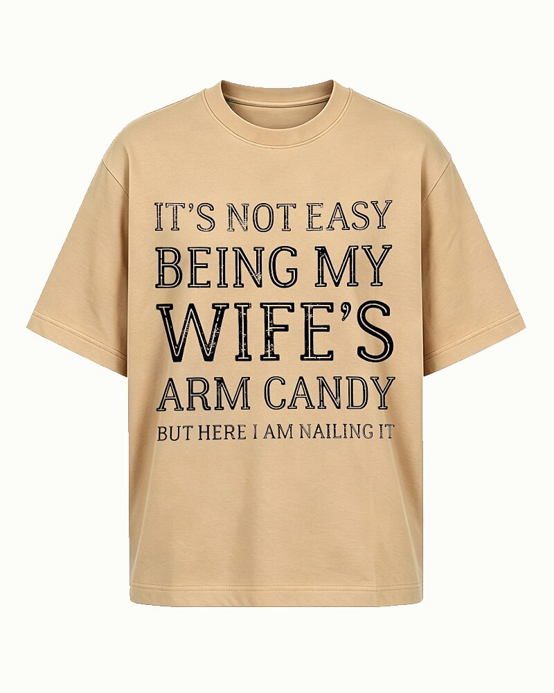 It's Not Easy Being My Wife's Arm Candy, but Here I Am Nailing It quote on Apricot cotton T-shirt