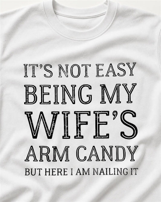 It's Not Easy Being My Wife's Arm Candy, but Here I Am Nailing It quote on Apricot cotton T-shirt